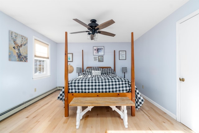 bedroom featuring a baseboard radiator, baseboards, light wood-style flooring, and a ceiling fan