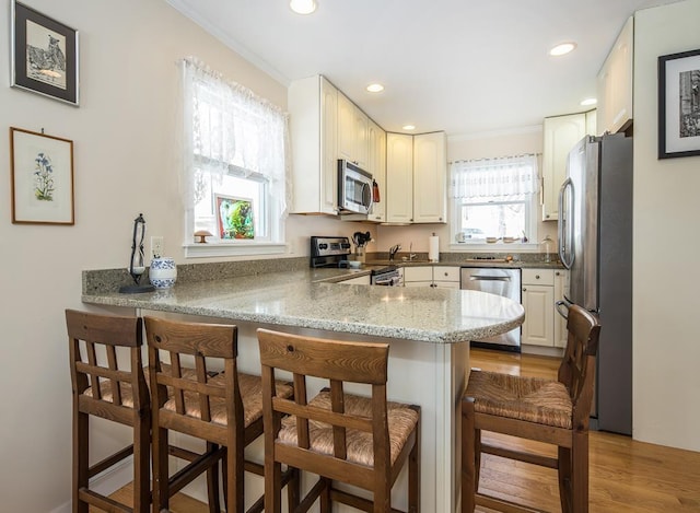 2400 Upper Cold River Rd, Shrewsbury, VT 05738 - kitchen featuring a kitchen breakfast bar, kitchen peninsula, light wood-type flooring, and stainless steel appliances