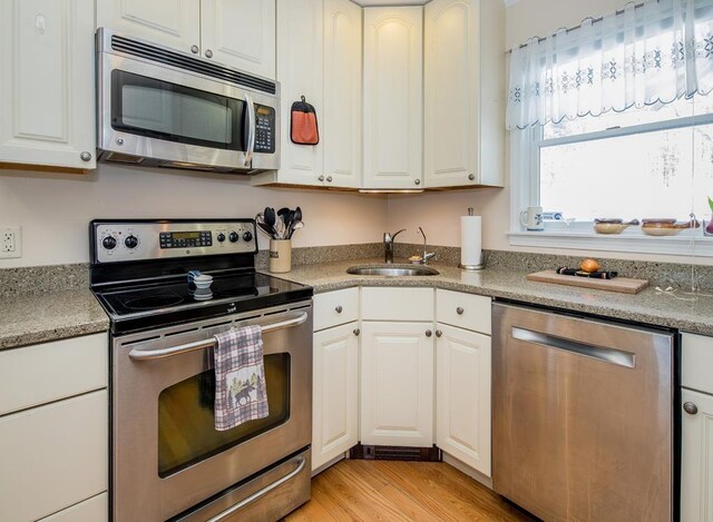 2400 Upper Cold River Rd, Shrewsbury, VT 05738 - kitchen with white cabinetry, light wood-type flooring, appliances with stainless steel finishes, and sink