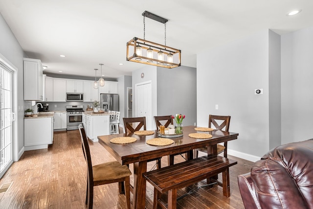 dining area featuring sink and wood-type flooring