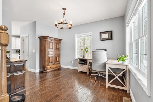 office with dark wood-type flooring and a notable chandelier