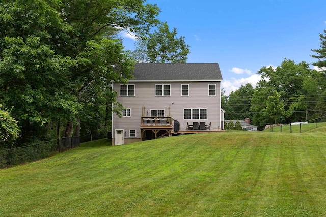 rear view of property with a yard and a wooden deck