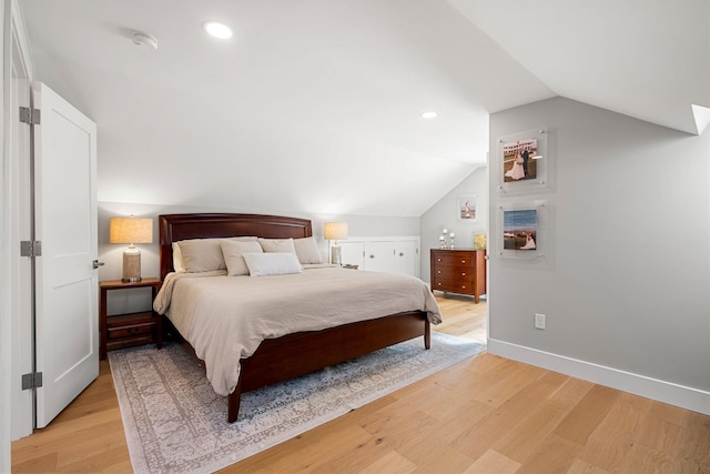 bedroom featuring light hardwood / wood-style floors and lofted ceiling