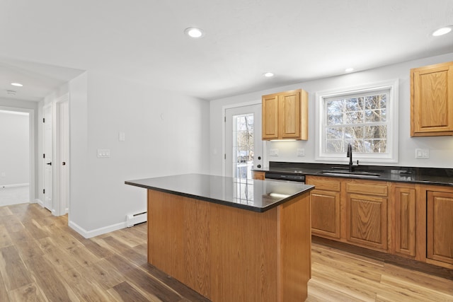 kitchen featuring a kitchen island, light hardwood / wood-style floors, a baseboard heating unit, sink, and dishwasher