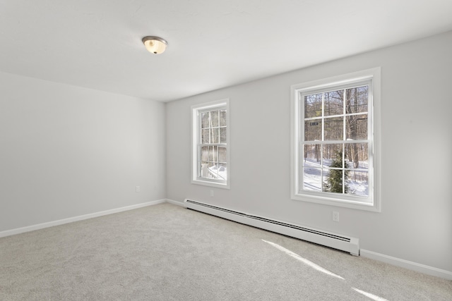 spare room featuring baseboard heating and light carpet