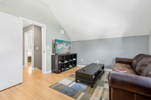 living room featuring vaulted ceiling and hardwood / wood-style floors