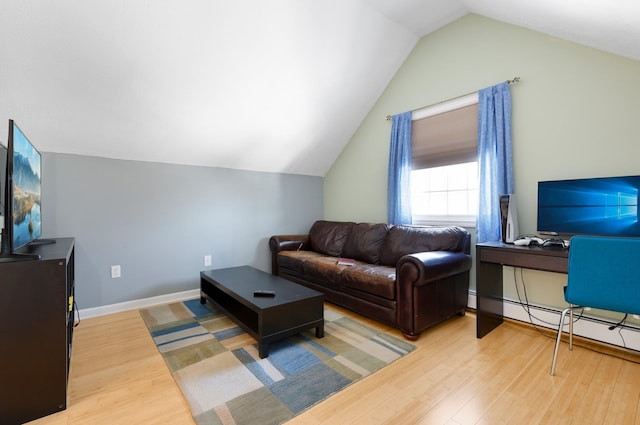 living room featuring hardwood / wood-style flooring, vaulted ceiling, and baseboard heating