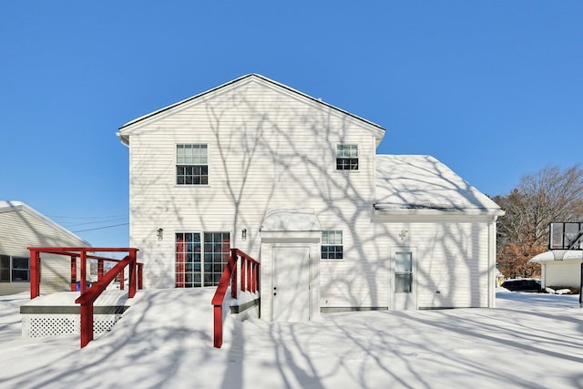 view of snow covered rear of property