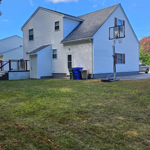 rear view of property featuring a lawn