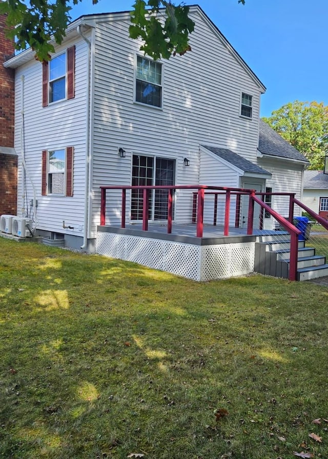 back of property with a lawn, ac unit, and a deck