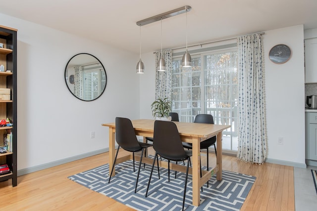 dining area with light wood-style floors and baseboards