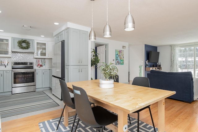 dining area with light wood finished floors and recessed lighting