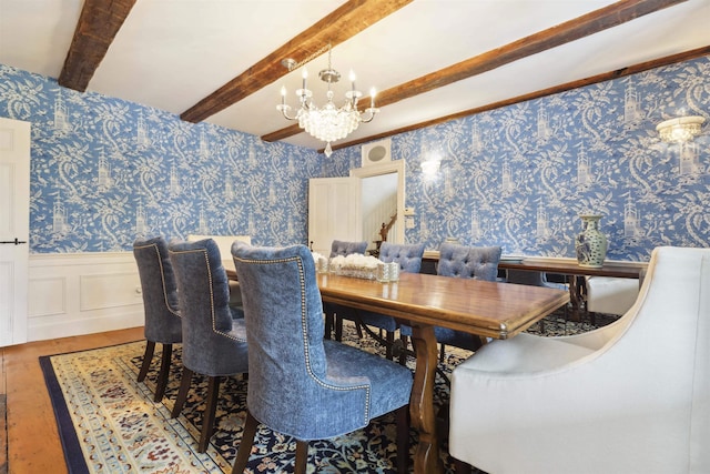 dining area with hardwood / wood-style floors, an inviting chandelier, and beam ceiling