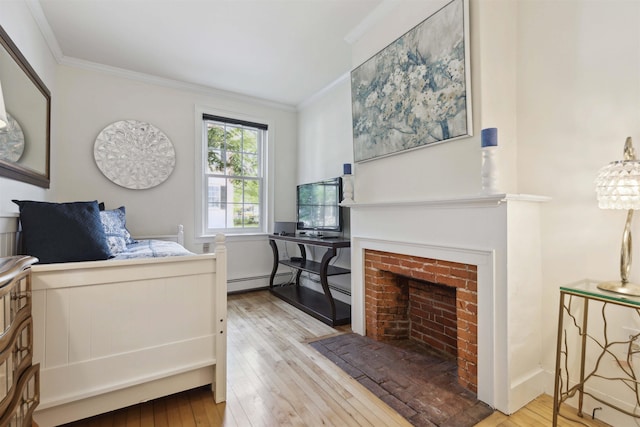 bedroom with light wood-type flooring, crown molding, a fireplace, and a baseboard heating unit