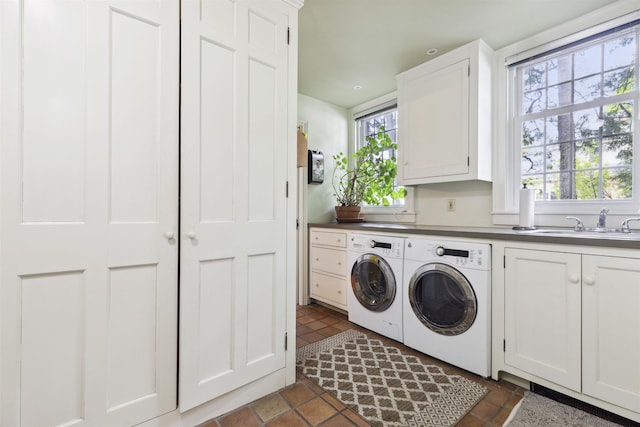 clothes washing area with sink, cabinets, and separate washer and dryer