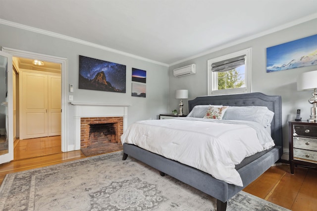 bedroom featuring an AC wall unit, ornamental molding, hardwood / wood-style floors, and a fireplace