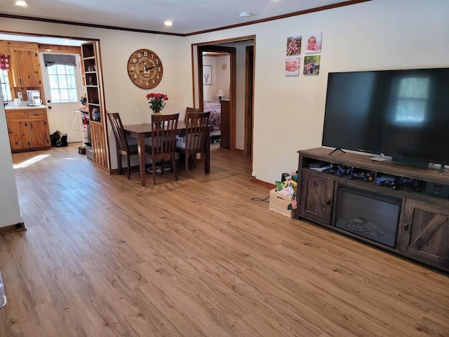 dining room with light wood-type flooring and crown molding