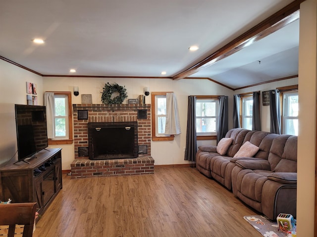 living room with hardwood / wood-style flooring, a brick fireplace, crown molding, and plenty of natural light