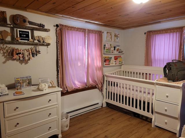 bedroom with multiple windows, hardwood / wood-style flooring, a baseboard heating unit, and wooden ceiling