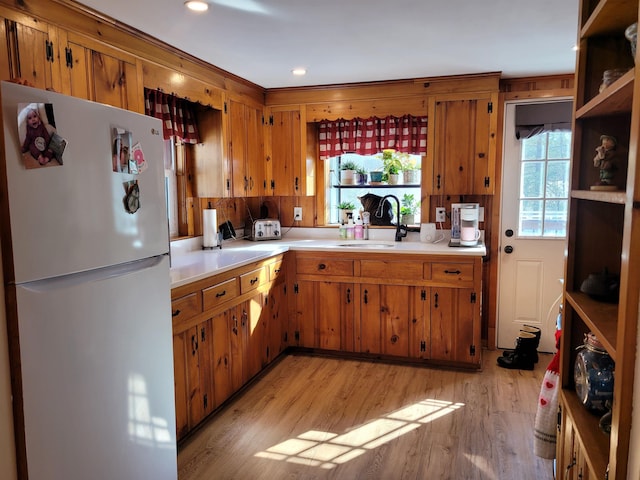 kitchen with white fridge, sink, and light hardwood / wood-style flooring