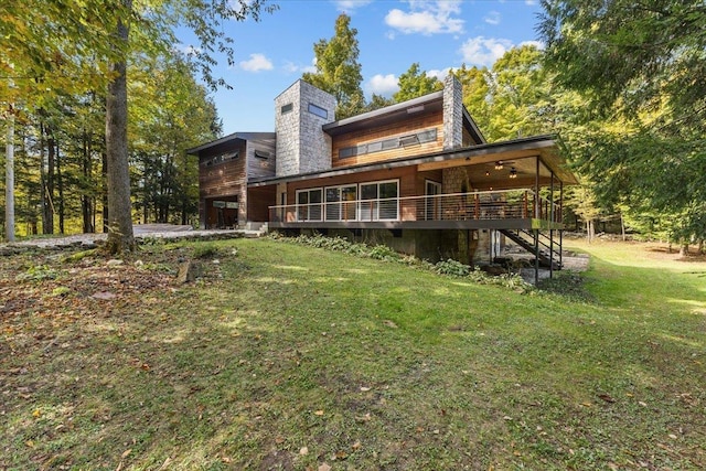 back of house with a lawn, ceiling fan, and a wooden deck