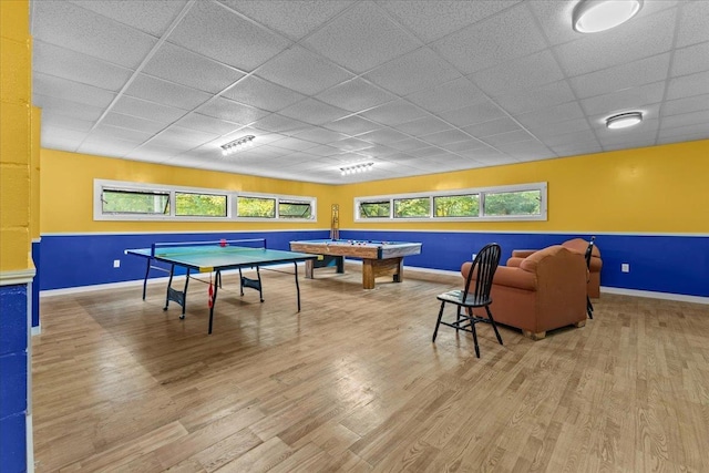 playroom with a paneled ceiling and wood-type flooring