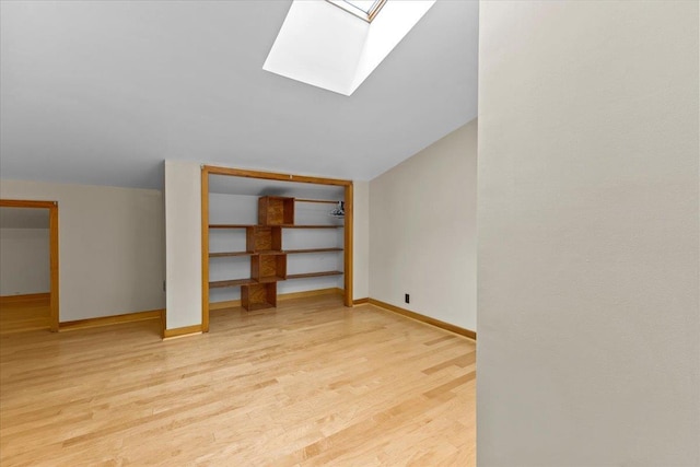 bonus room with light hardwood / wood-style flooring and lofted ceiling with skylight