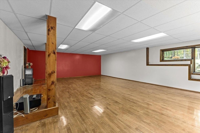 basement with hardwood / wood-style flooring and a paneled ceiling