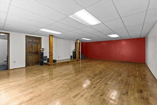 basement featuring a paneled ceiling and hardwood / wood-style floors