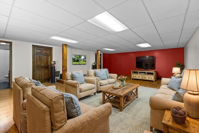 living room with a paneled ceiling and wood-type flooring