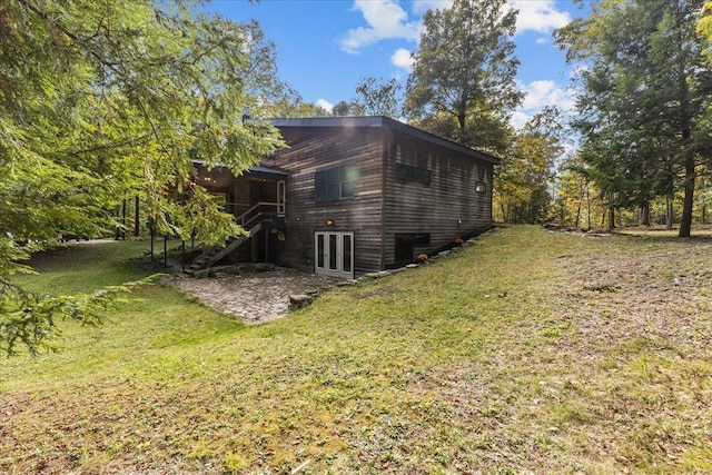 view of side of home with a yard, a patio, and french doors