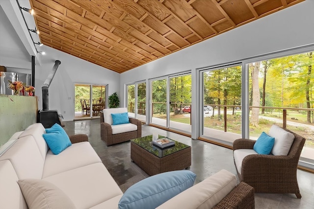 sunroom / solarium featuring wood ceiling, a wood stove, and vaulted ceiling