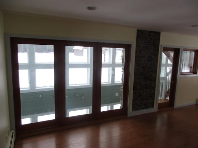 entryway featuring a baseboard heating unit, dark hardwood / wood-style floors, and a wealth of natural light