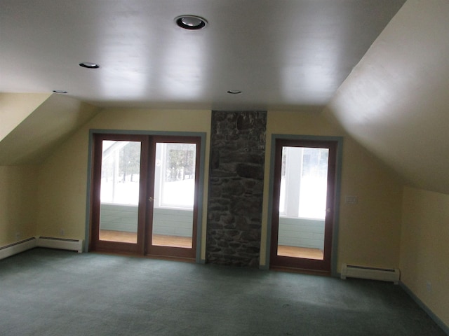 bonus room featuring dark carpet, a wealth of natural light, and a baseboard heating unit