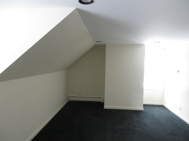 bonus room featuring dark carpet, baseboard heating, and vaulted ceiling