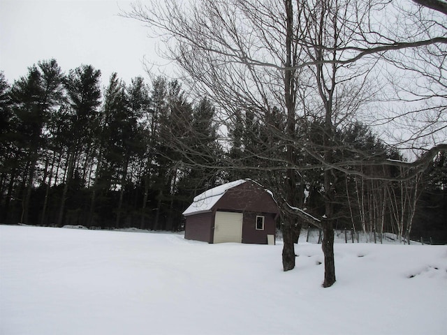 yard covered in snow with a garage and an outbuilding