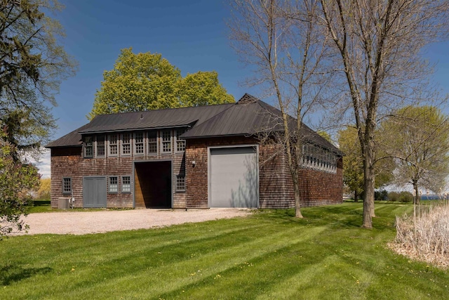 back of house featuring a yard, central AC unit, and a garage