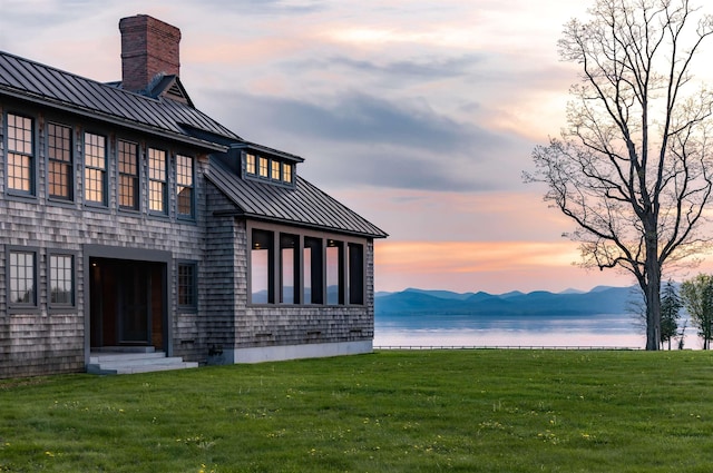 exterior space featuring a mountain view and a lawn