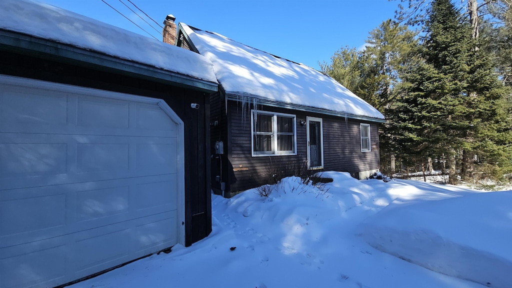 view of snowy exterior featuring a garage