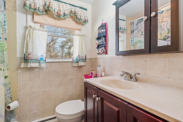 bathroom with vanity, tile walls, and toilet