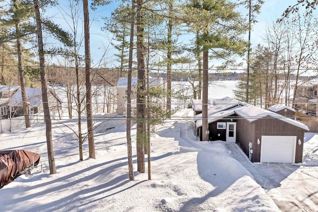 yard layered in snow featuring a garage