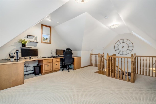 carpeted home office featuring vaulted ceiling