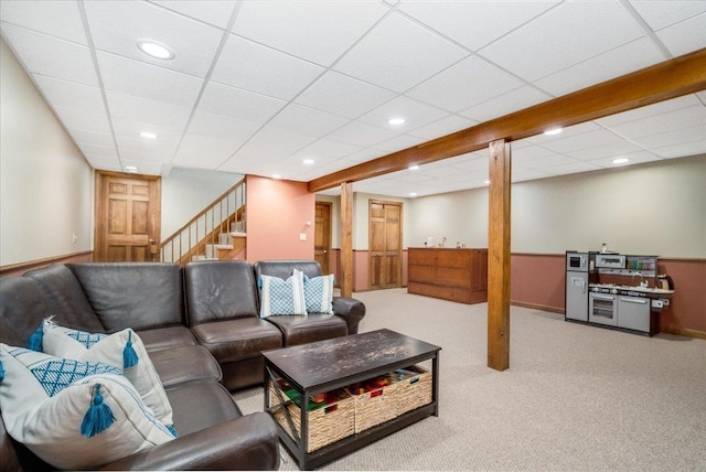 living room with a drop ceiling and light colored carpet