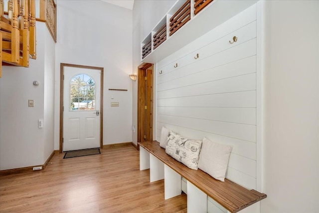 mudroom with light hardwood / wood-style flooring and a high ceiling