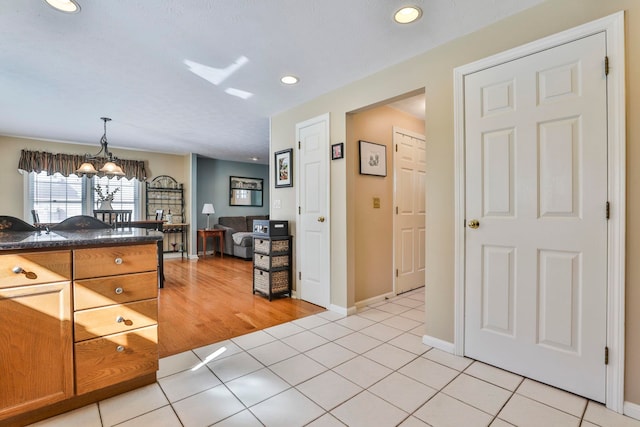 kitchen featuring light tile patterned floors, pendant lighting, and an inviting chandelier