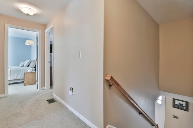 hallway featuring light colored carpet