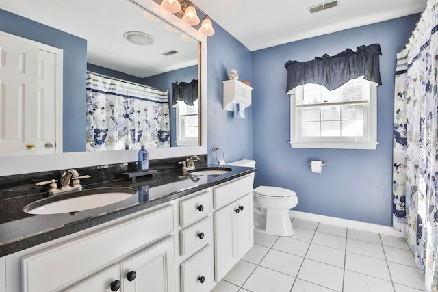 bathroom with toilet, tile patterned flooring, curtained shower, and vanity