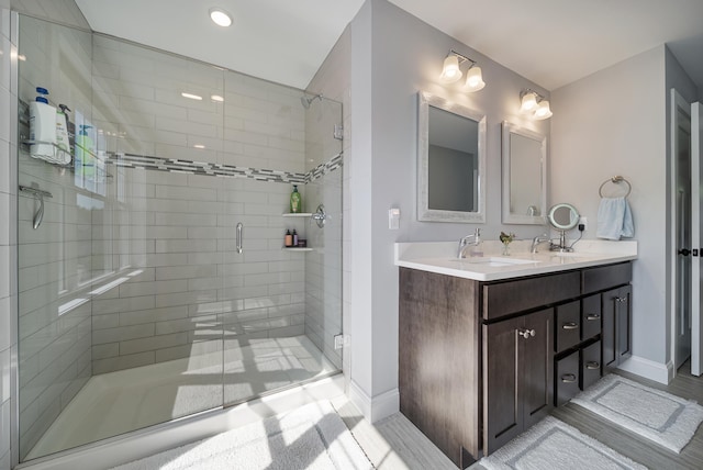 bathroom featuring vanity and a shower with door