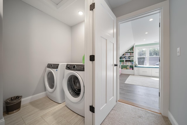 clothes washing area featuring washing machine and dryer and light wood-type flooring