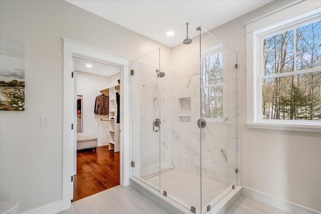 bathroom with plenty of natural light, wood-type flooring, and a shower with shower door